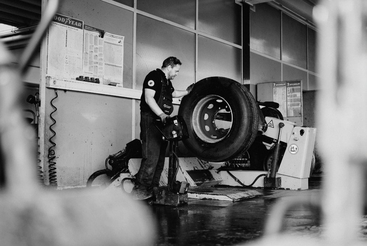 Mitarbeiter bedient eine Maschine zur Reifenbearbeitung – präziser technischer Ablauf im Werkstattbereich von Plankenauer.