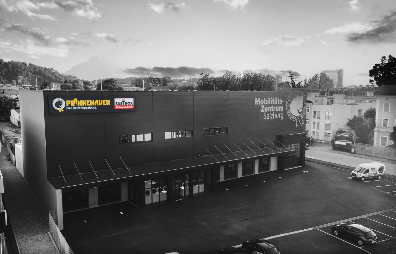 Moderne Außenansicht des Mobilitätszentrums Salzburg mit großzügiger Glasfassade und Firmenlogo.