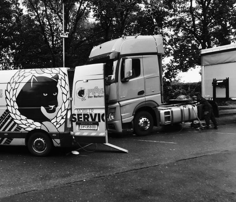 Ein mobiler Reifenservice-LKW steht vor einer Werkstatt bereit für den Außeneinsatz.